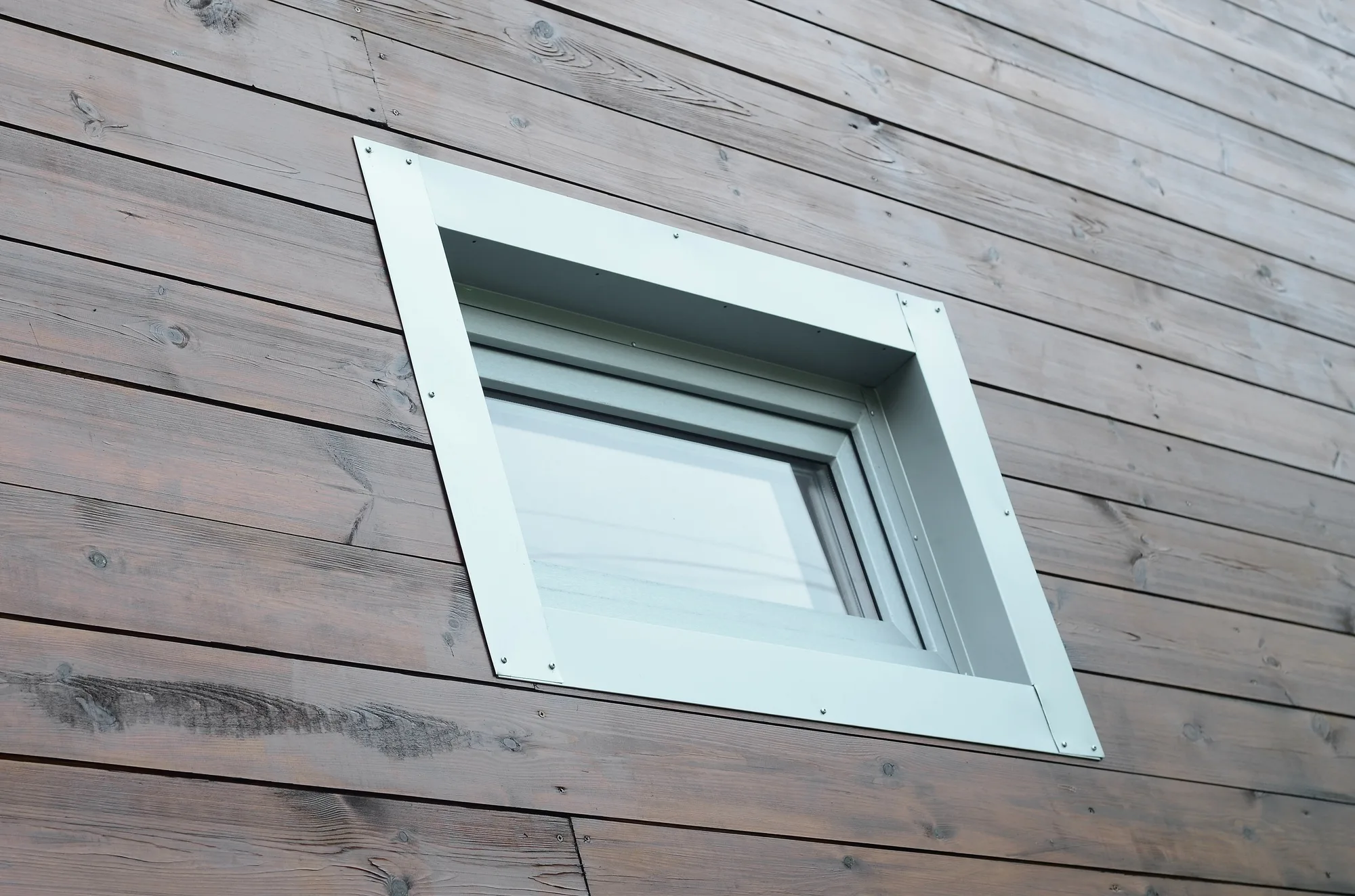 Plastic PVC window in modern passive wooden house facade wall